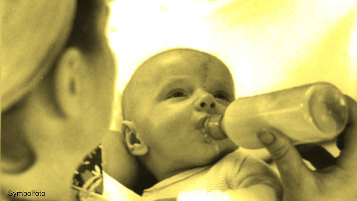 Eine Frau gibt einem Baby die Flasche.