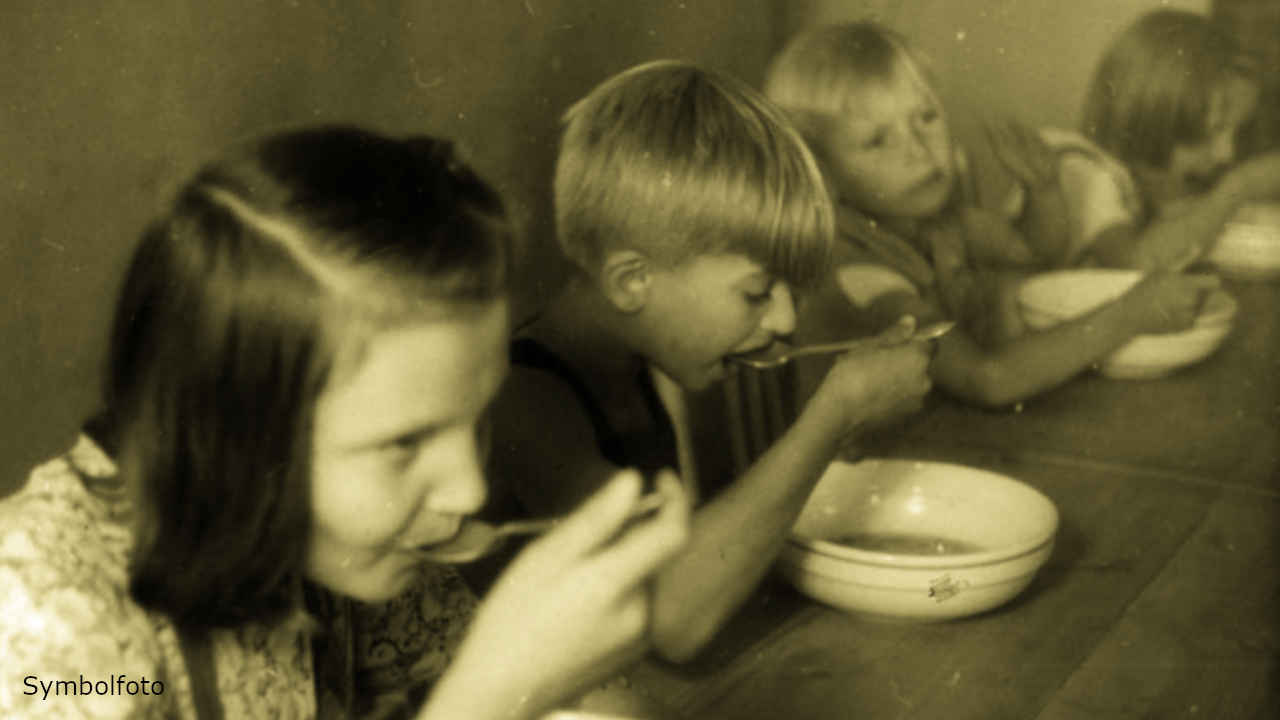 Mehrere Kinder essen gemeinsam an einem Tisch.